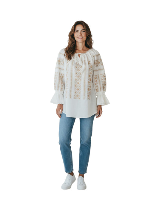 Woman wearing a white embroidered blouse and blue jeans on a white background