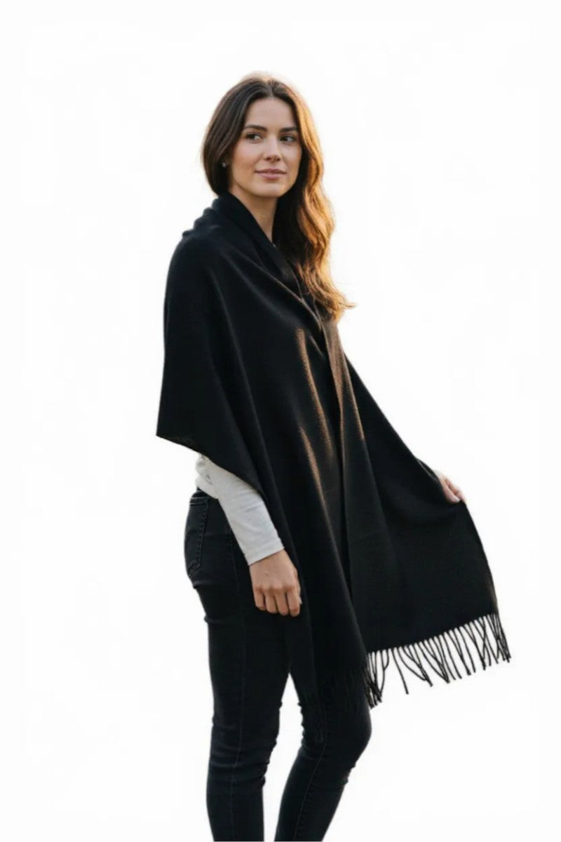 Woman wearing a black poncho with a white background