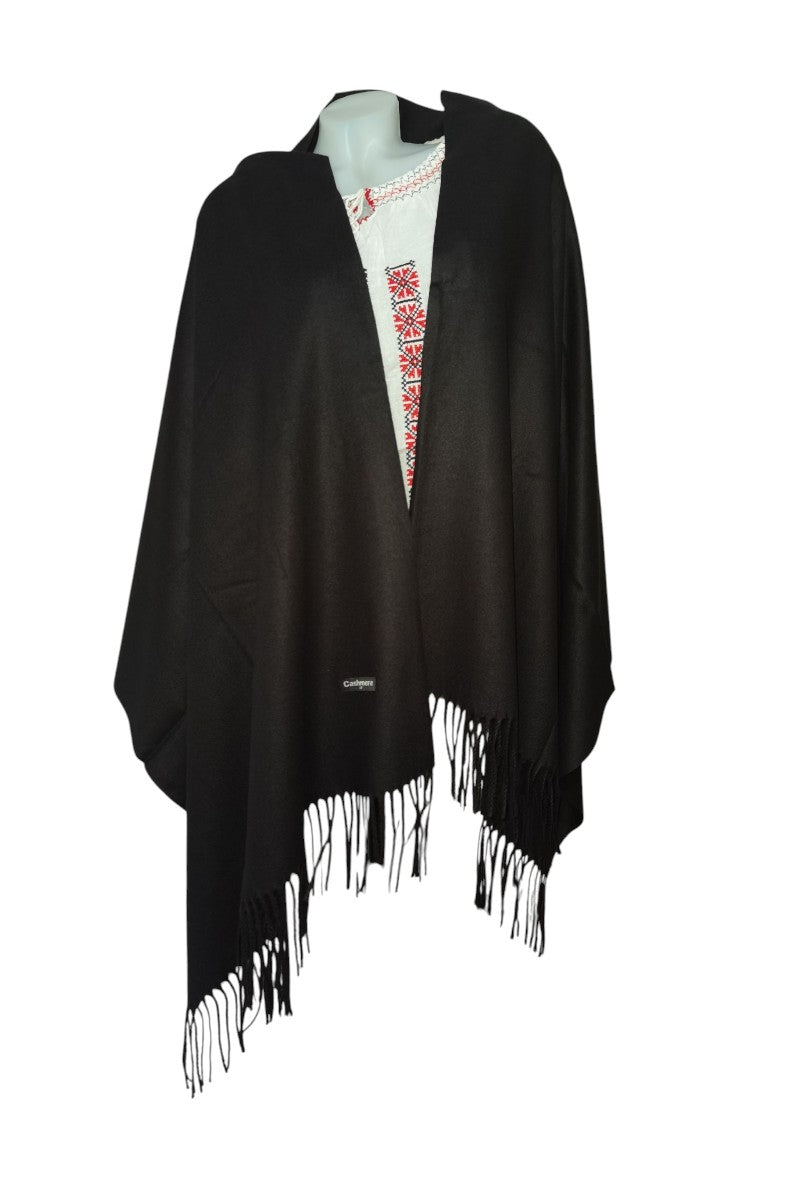 Black poncho with fringe on a mannequin against a white background