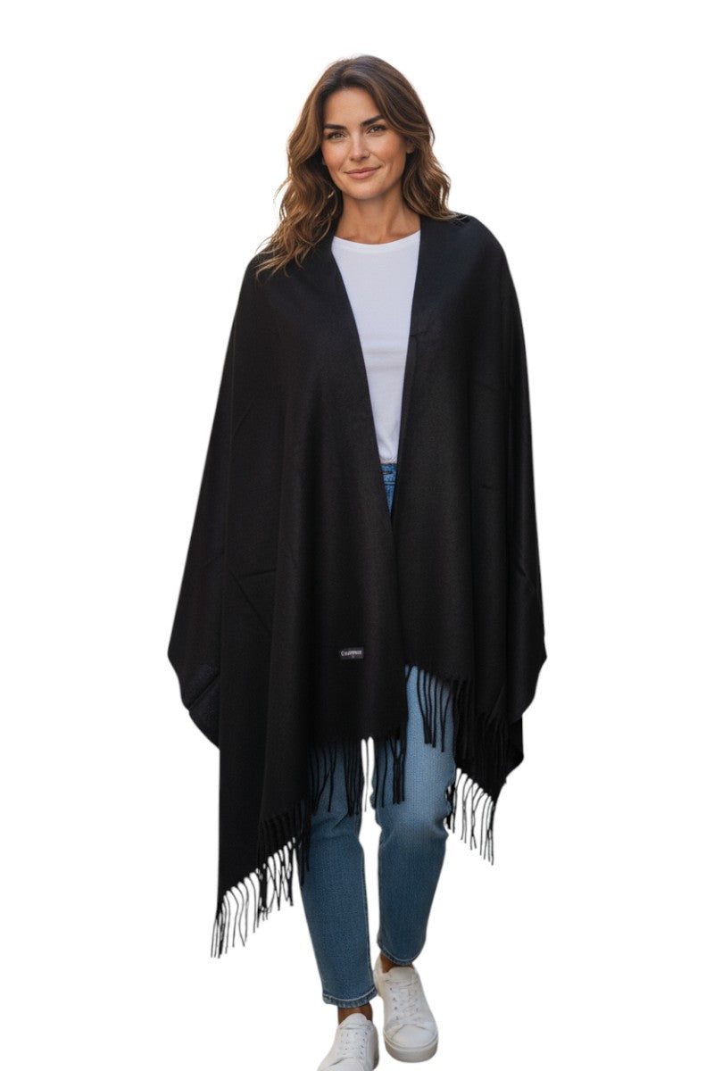 Woman wearing a black fringed poncho on a white background